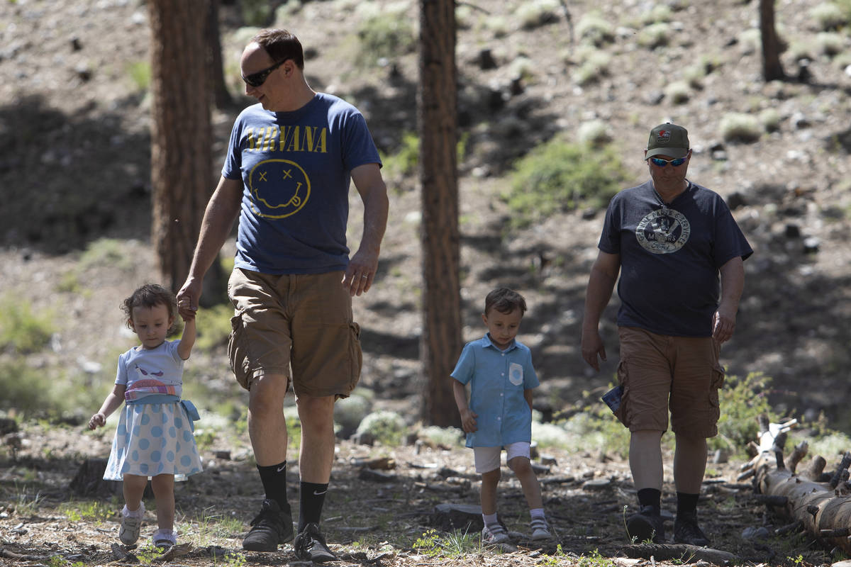 Thomas Doyle, left, walks his daughter, Mia Doyle, 2, back to their campsite as his brother, Jo ...