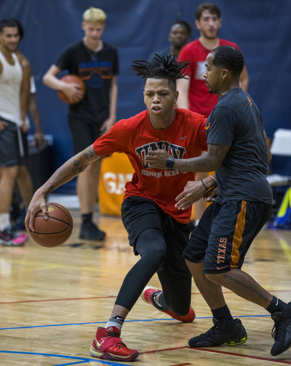 UNLV freshman wing Nick Blake, left, is defended by coach Eric Taylor on the court at the Tarka ...
