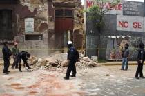 A policeman removes rubble from a building damaged by an earthquake in Oaxaca, Mexico, Tuesday, ...