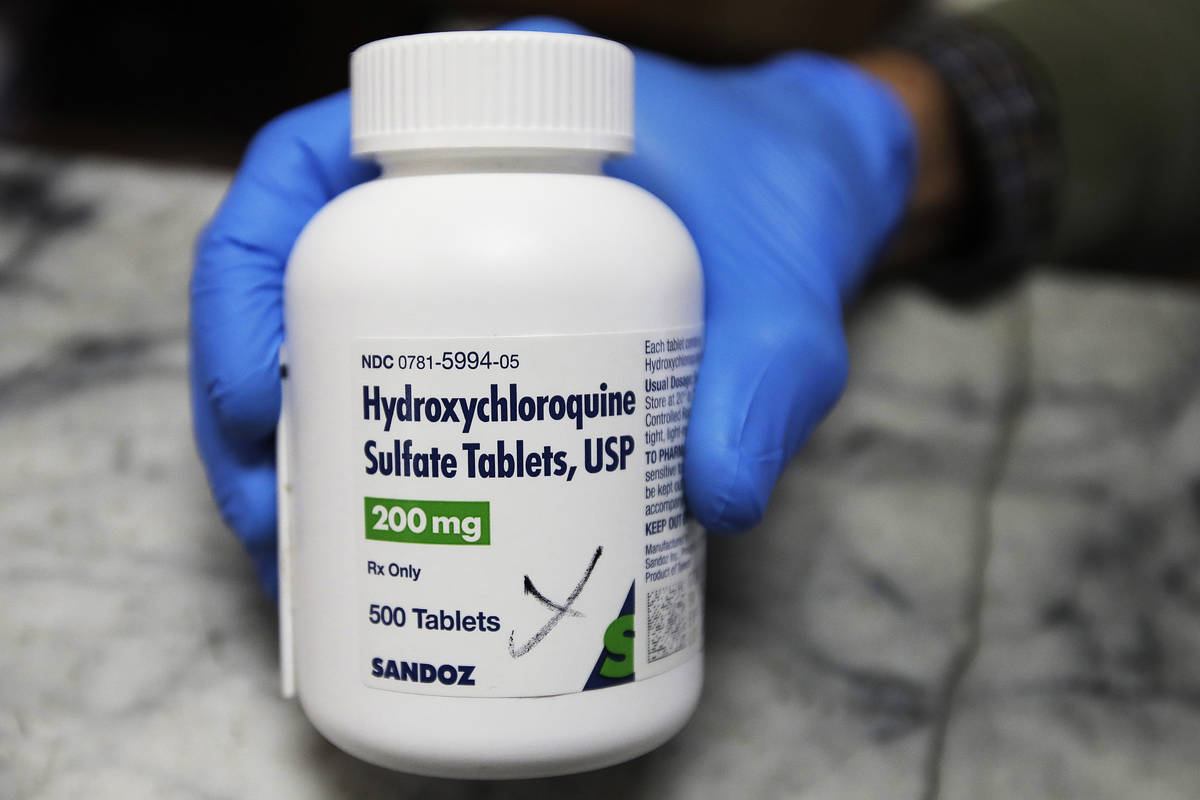 In this April 6, 2020, file photo, a pharmacist holds a bottle of the drug hydroxychloroquine i ...