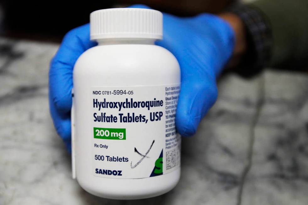 In this April 6, 2020, file photo, a pharmacist holds a bottle of the drug hydroxychloroquine i ...