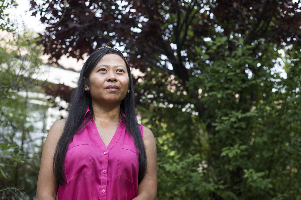 Joe Junio, a taxi driver and real estate agent, stands for a portrait outside her home on Wedne ...