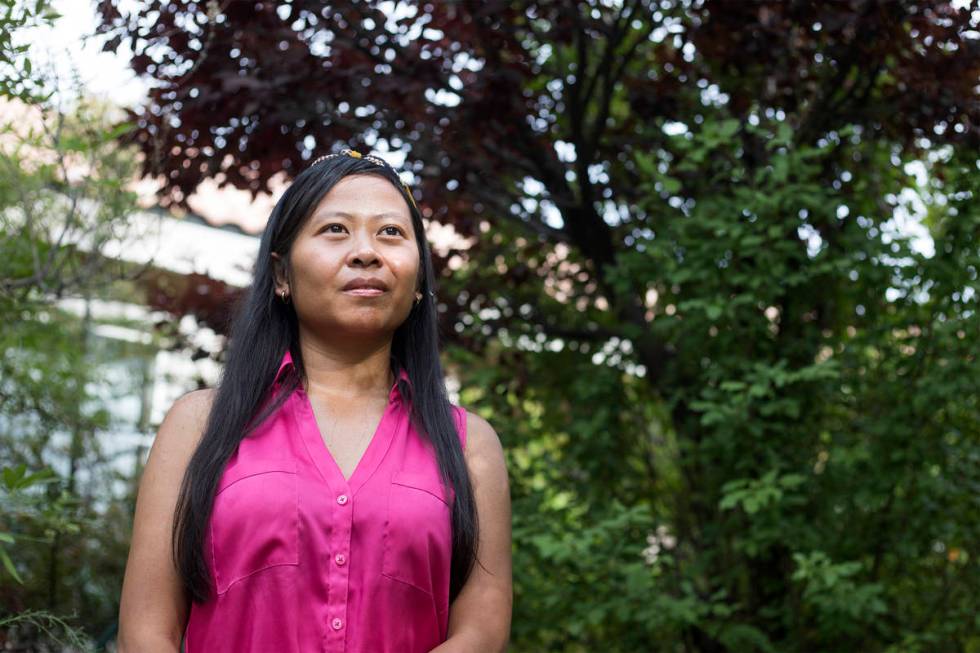 Joe Junio, a taxi driver and real estate agent, stands for a portrait outside her home on Wedne ...