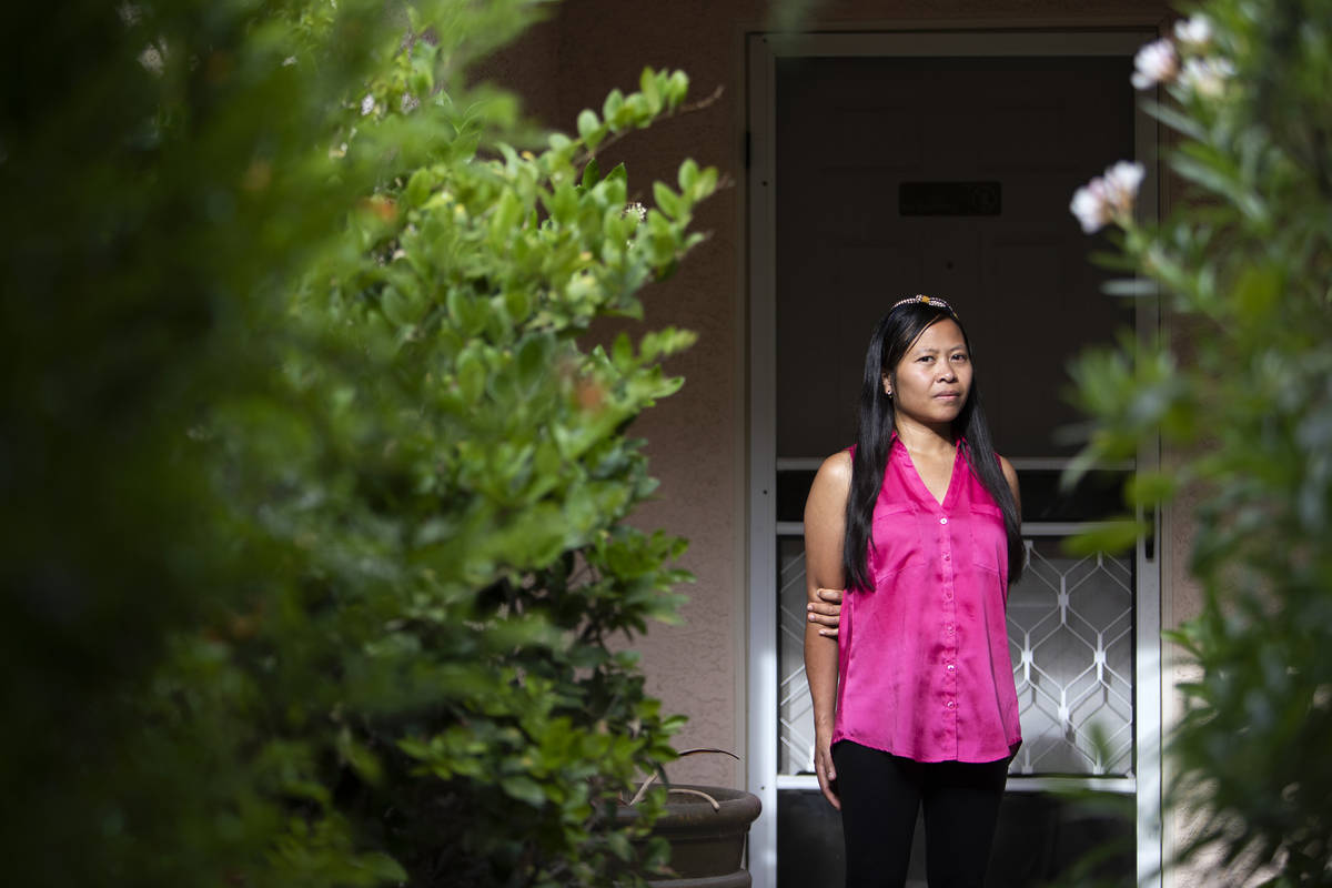 Joe Junio, a taxi driver and real estate agent, stands for a portrait outside her home on Wedne ...