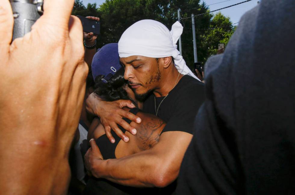 Rapper T.I. hugs a family member of Rayshard Brooks during protests, Saturday, June 13, 2020, n ...