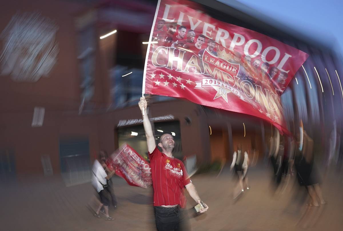 A Liverpool supporter celebrates outside Anfield Stadium in Liverpool, England, Thursday, June ...