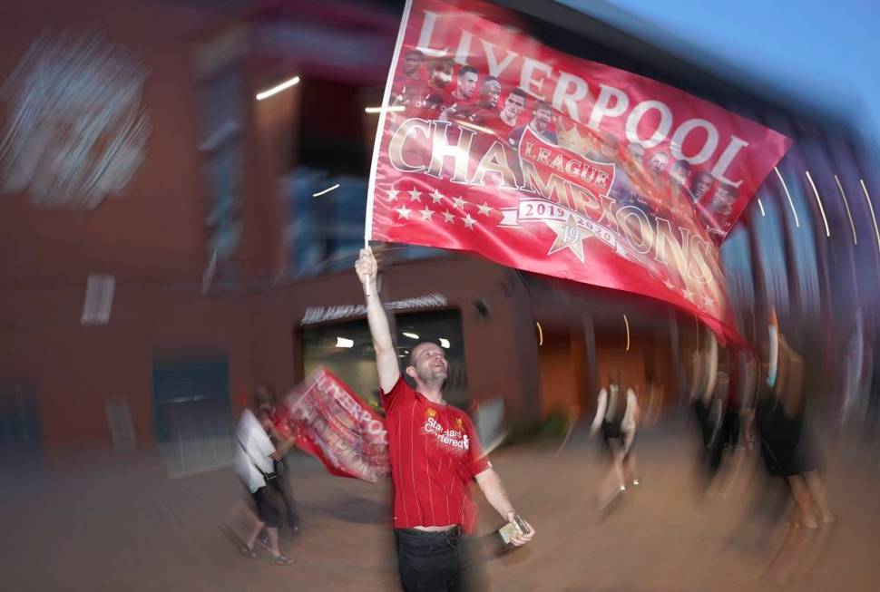 A Liverpool supporter celebrates outside Anfield Stadium in Liverpool, England, Thursday, June ...