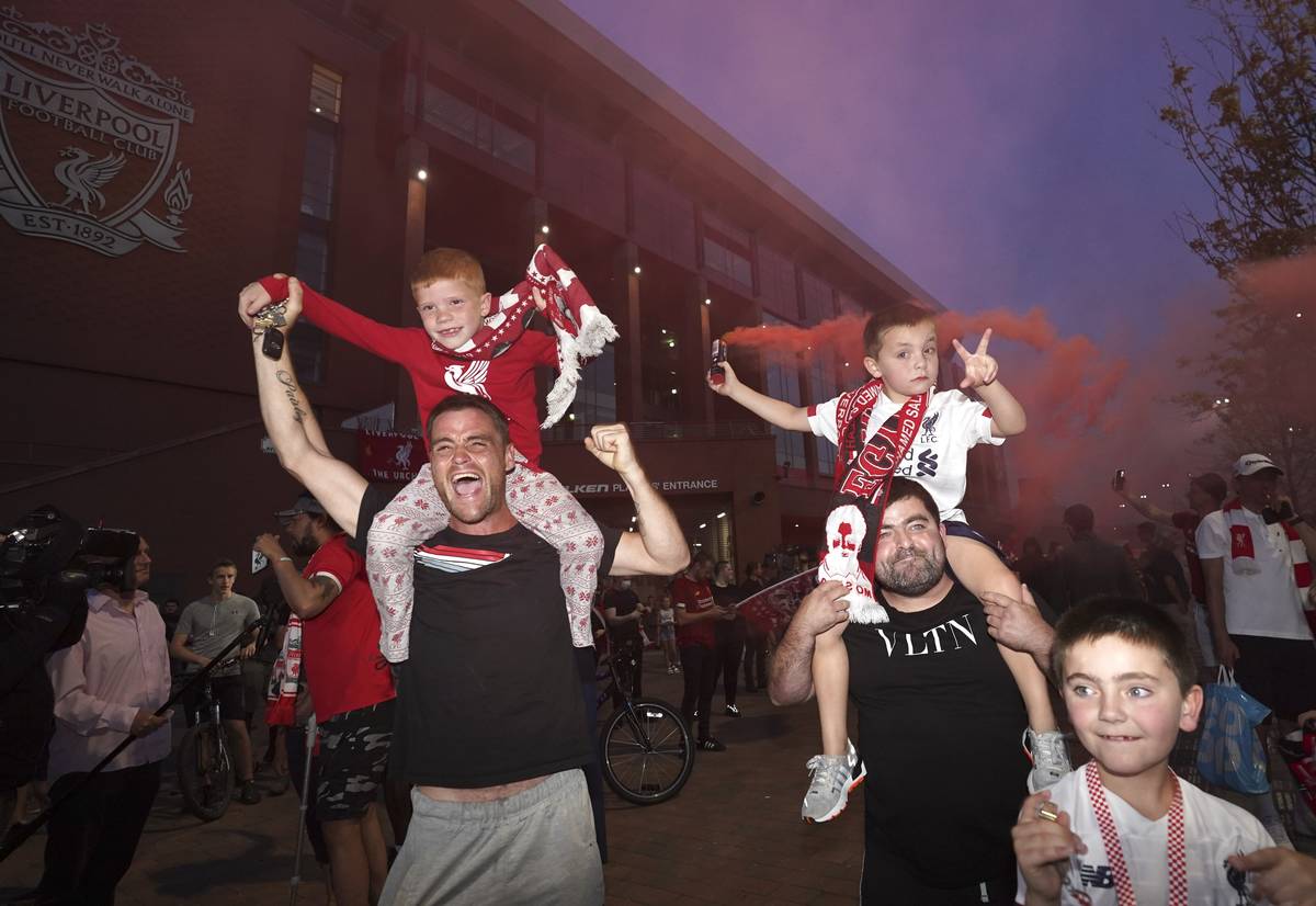 Liverpool supporters celebrate as they gather outside of Anfield Stadium in Liverpool, England, ...