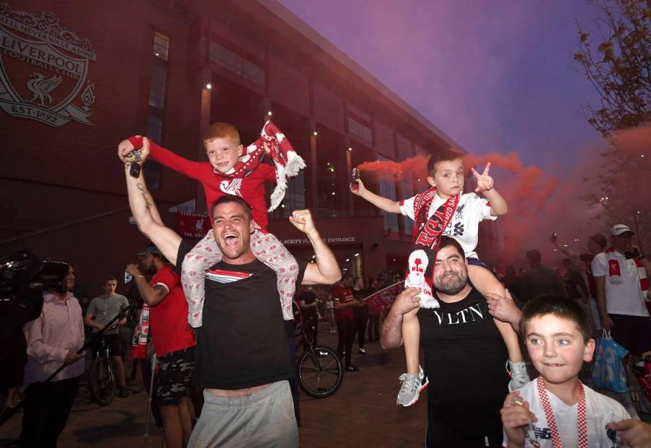 Liverpool supporters celebrate as they gather outside of Anfield Stadium in Liverpool, England, ...