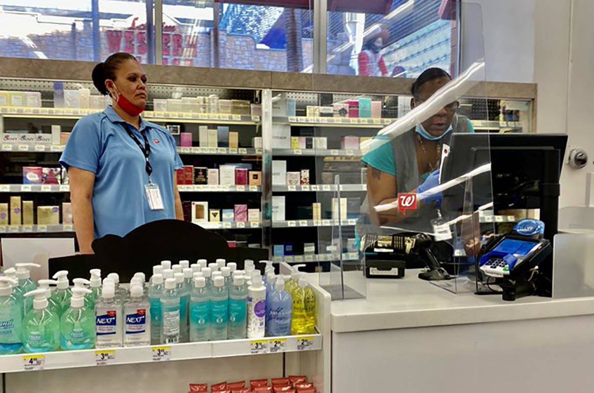 Clerks at Walgreens at Fremont and 4th streets wear face masks below their chins on Friday, Jun ...