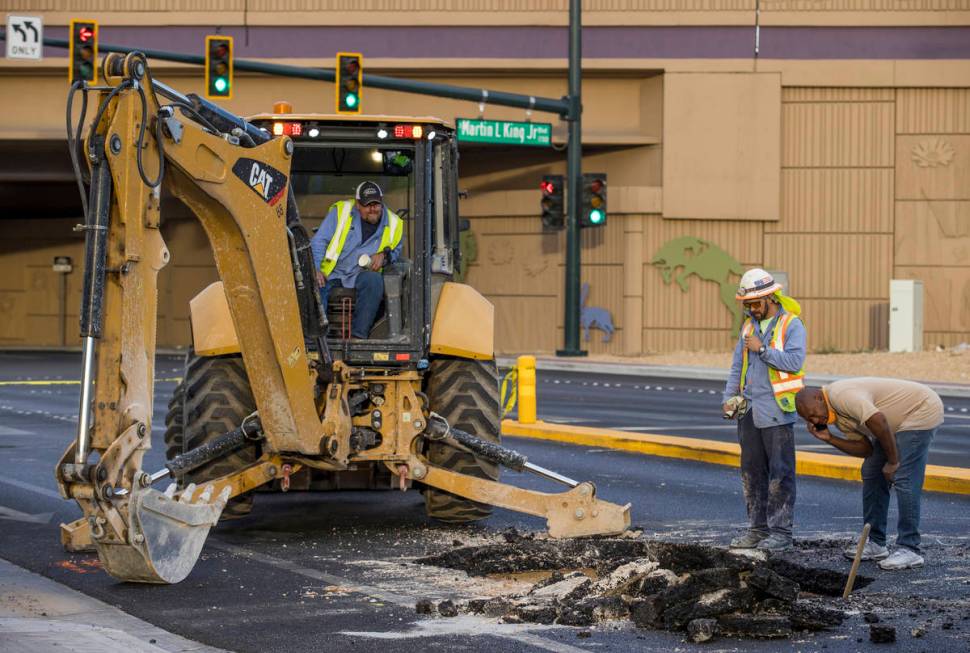 Las Vegas Valley Water District workers inspect a sinkhole which opened up and damaged vehicles ...