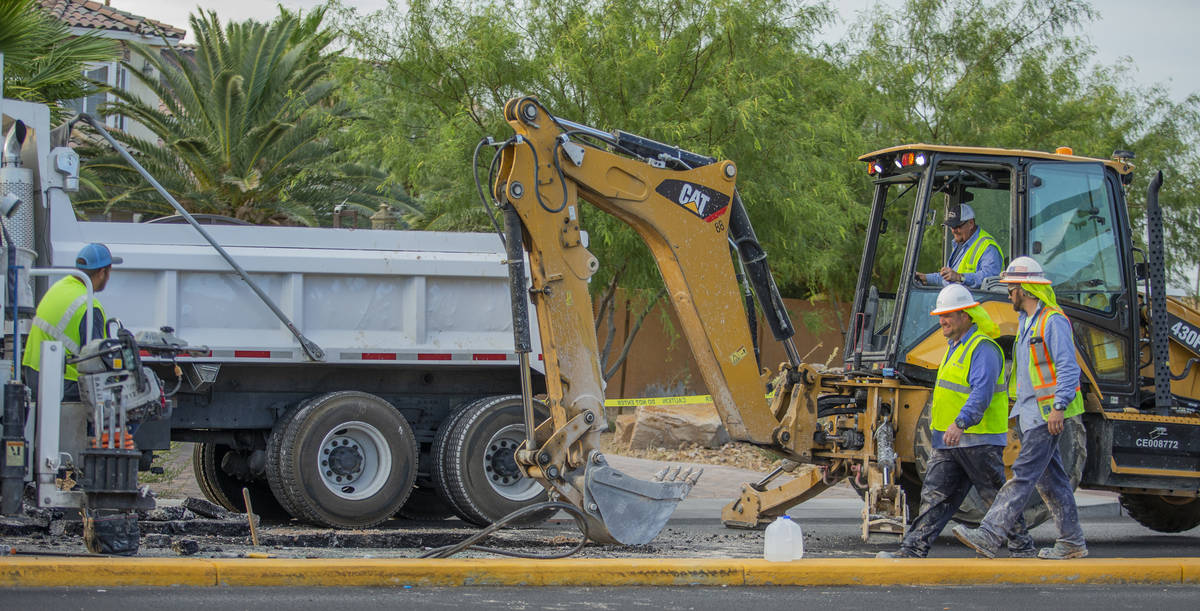 Las Vegas Valley Water District workers repair a sinkhole which opened up and damaged vehicles ...