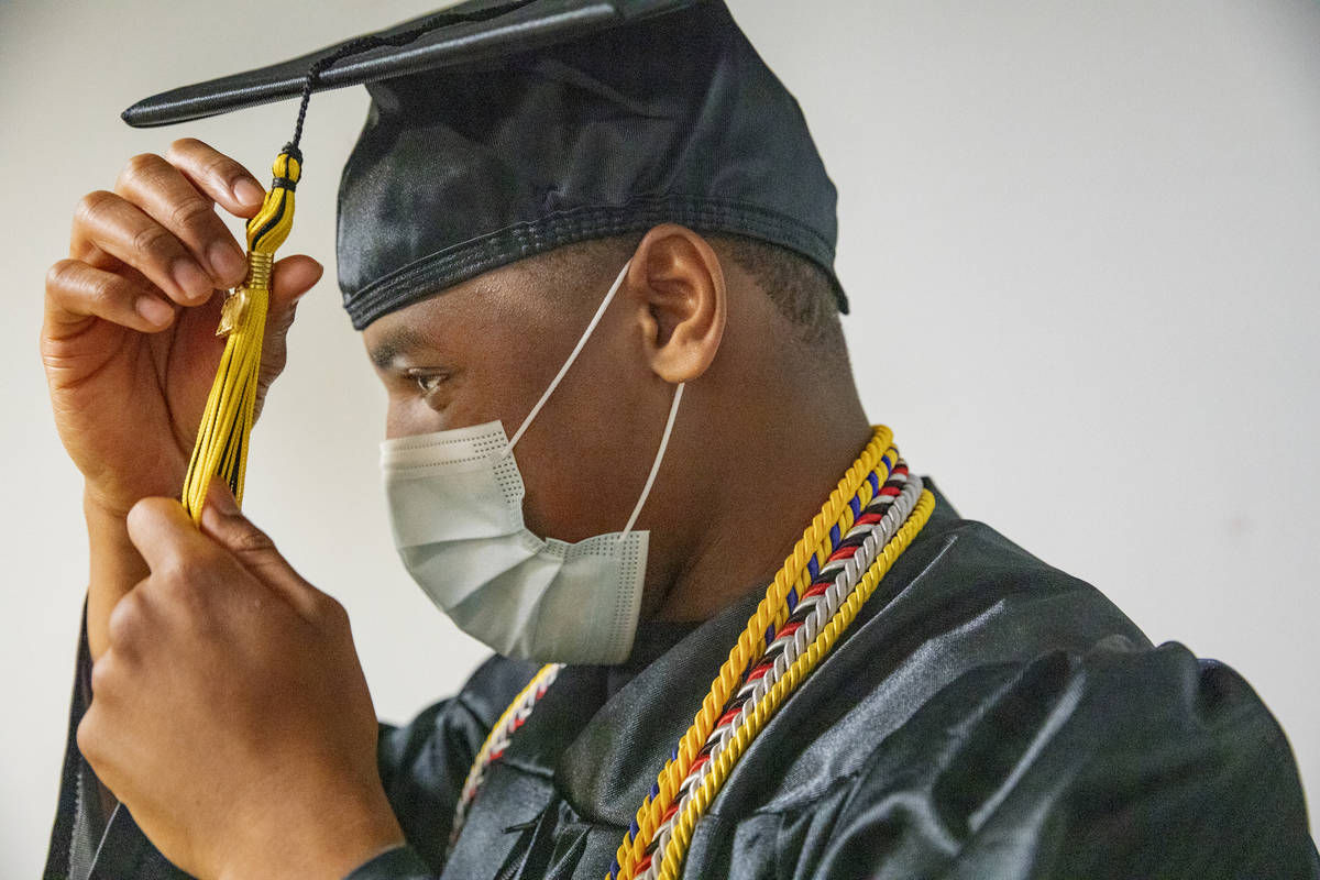 Jaden Hines, 18, a graduate of Nevada State High School, puts on his cap and gown for a graduat ...