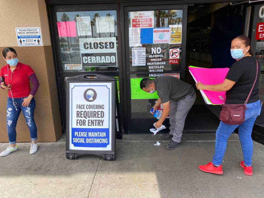 Eusebio Hernandez sanitizes doors as vendors arrive prior to opening at Bonanza Swapmeet on Eas ...