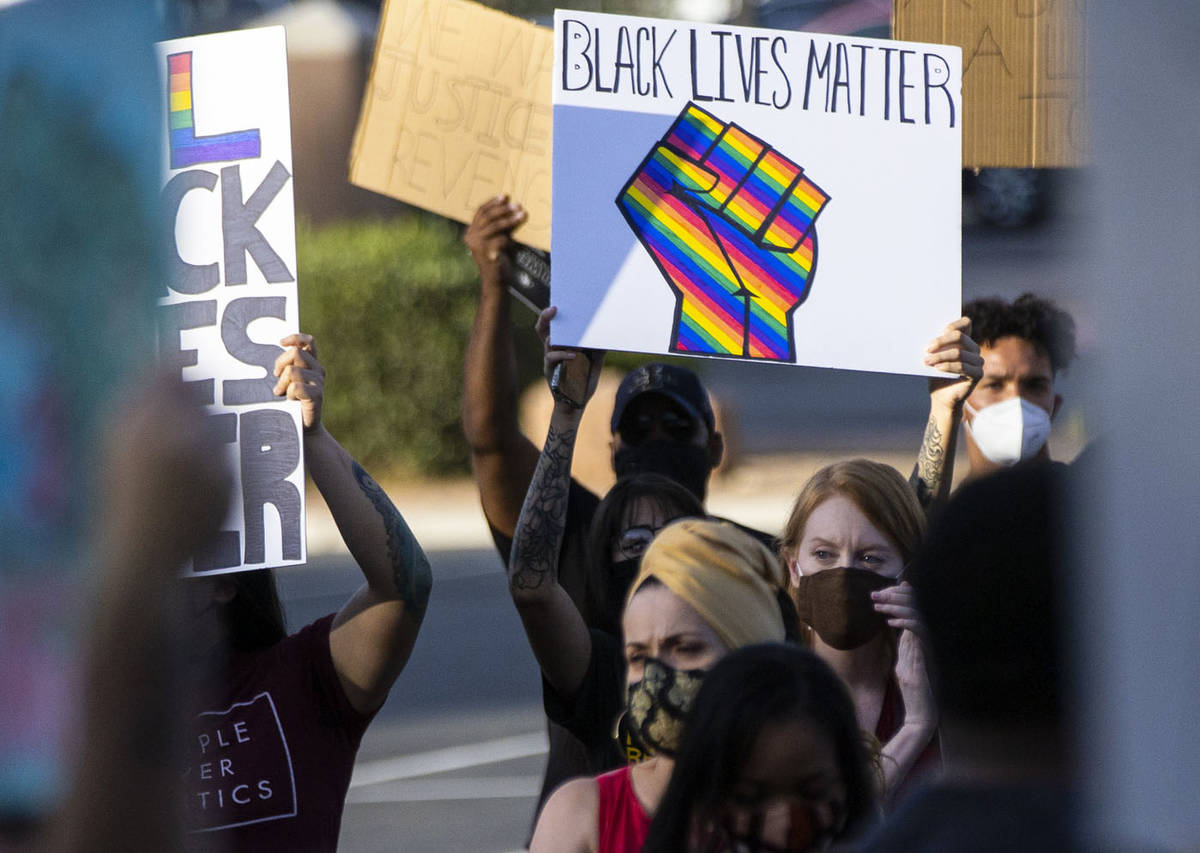People hold up their signs during a Black Lives Matter rally at the Sawyer Building in Las Vega ...
