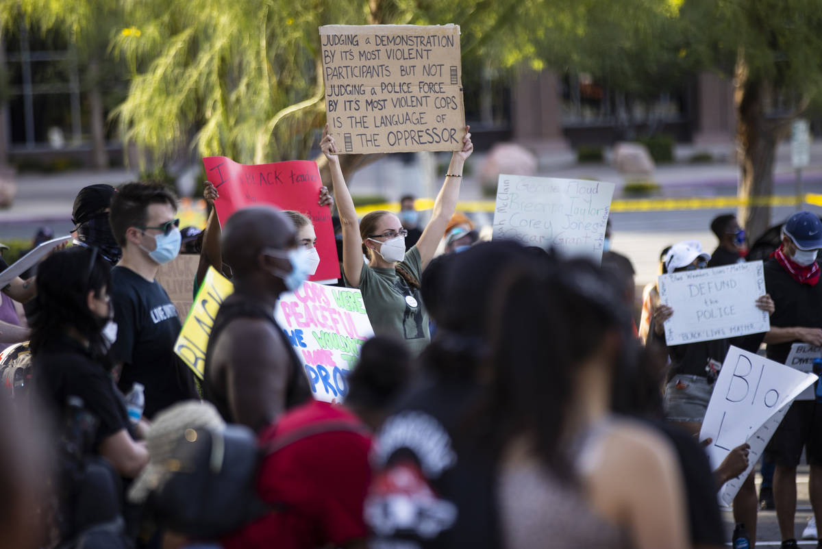 People hold up signs during a Black Lives Matter rally at the Sawyer Building in Las Vegas on F ...