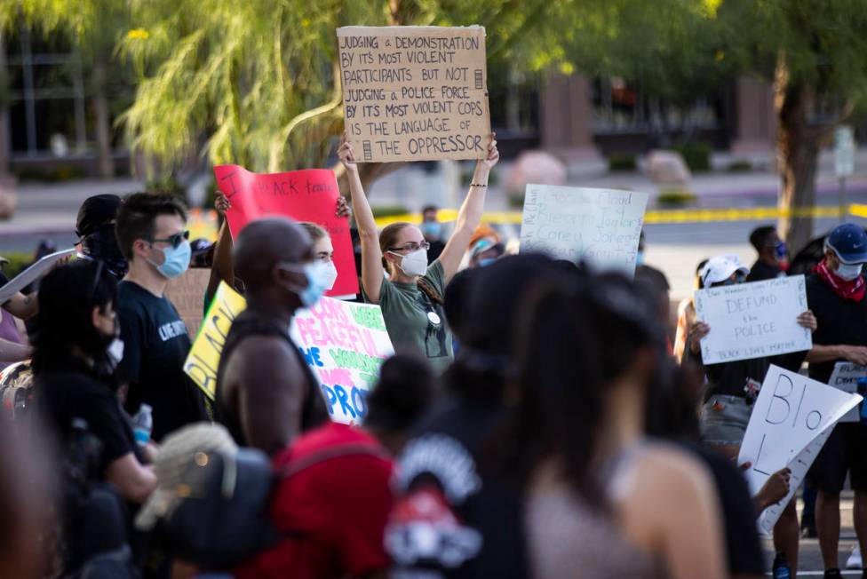 People hold up signs during a Black Lives Matter rally at the Sawyer Building in Las Vegas on F ...