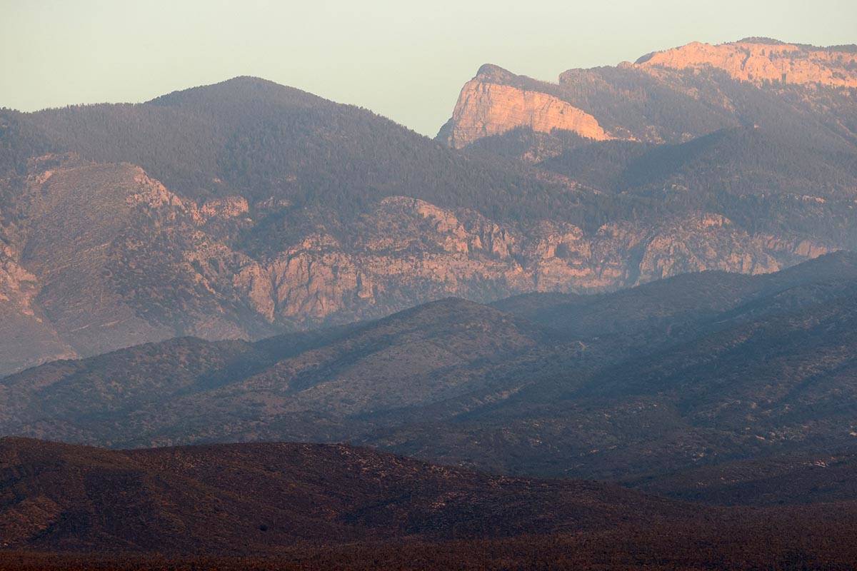 The sun rises on a ridgeline as crews battle the Mahogany Fire on Mount Charleston near Las Veg ...