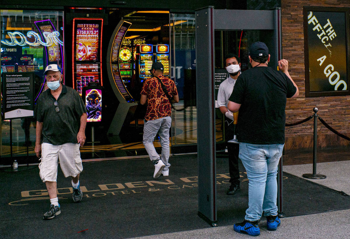 A man stops for a temperature check at the Golden Gate in downtown Las Vegas on Saturday, June ...