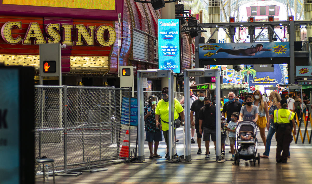 People walk through temperature scanners at the Fremont Street Experience in downtown Las Vegas ...