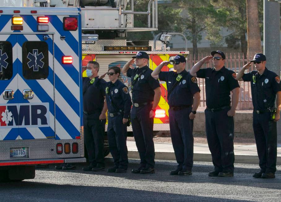 Clark County Firefighters salut during a procession as an ambulance carrying a wounded Las Vega ...