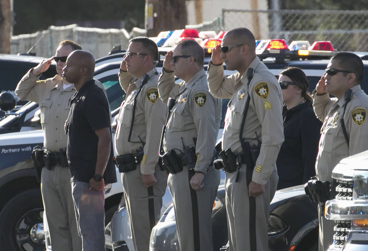 Las Vegas police officers salut during a procession as an ambulance carrying a wounded Las Vega ...