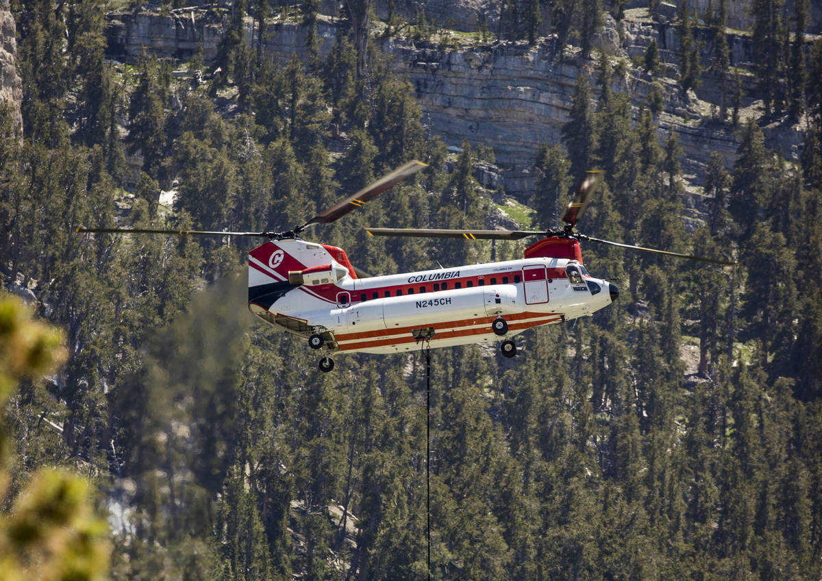 A helicopter with water bucket fills up at the Lee Canyon Ski Resort for another drop over the ...