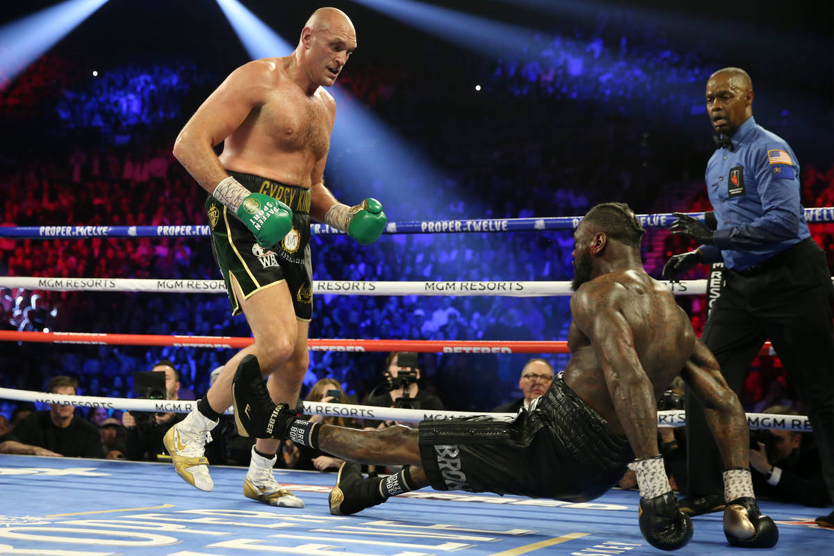Tyson Fury, left, knocks down Deontay Wilder in round 5 of the WBC world heavyweight championsh ...
