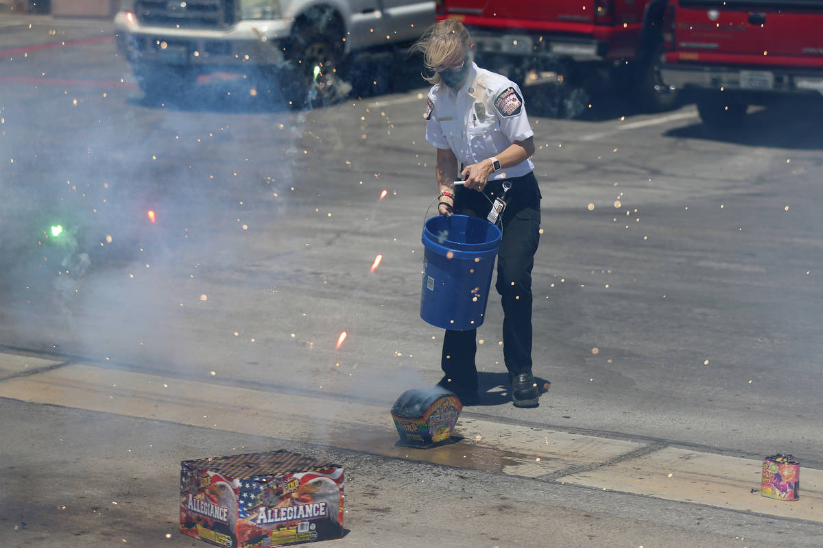 Las Vegas Fire and Rescue's fire inspector Melanie Dennon pours water on a box of fireworks dur ...