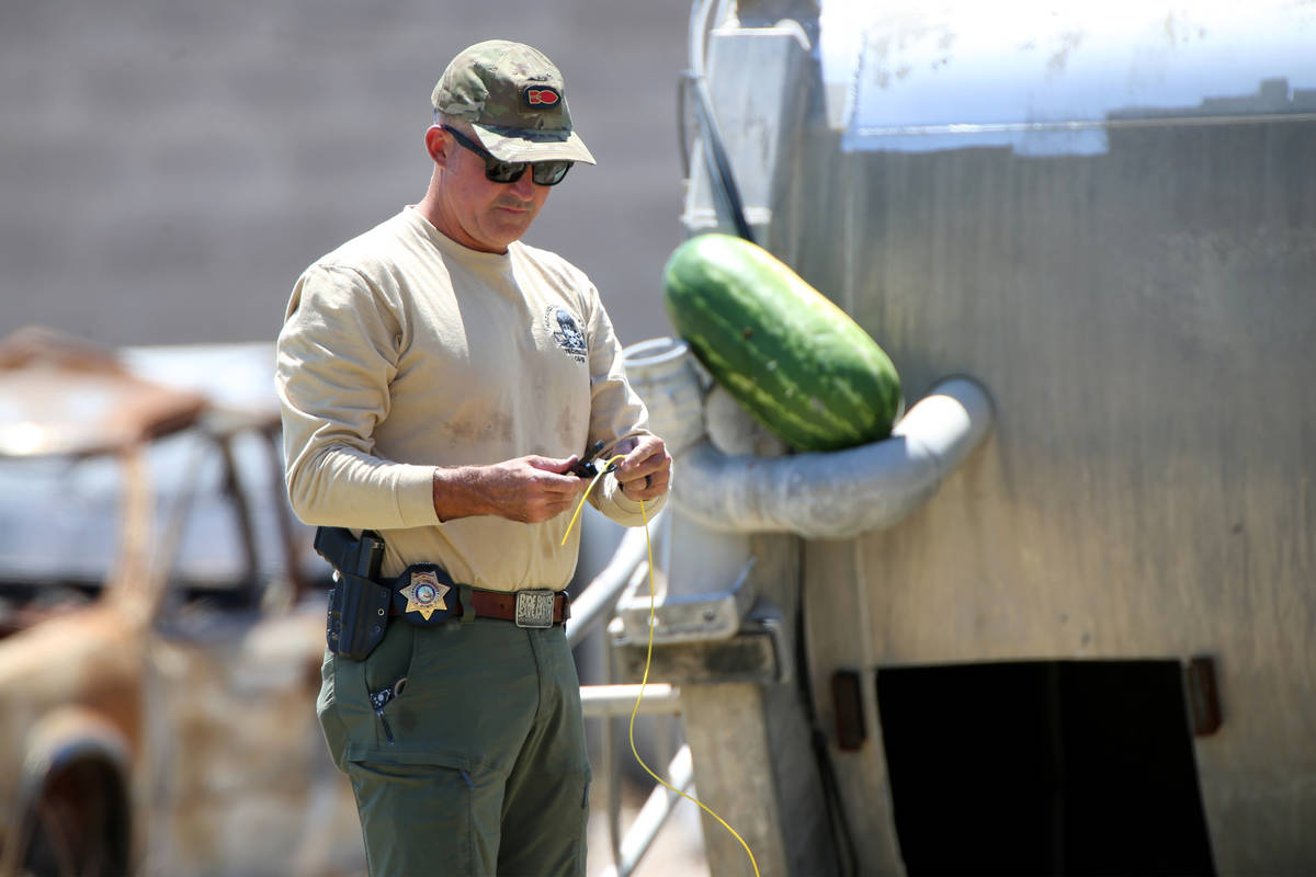 Mark Duncan, bomb squad technician with Las Vegas Fire and Rescue, sets up a charge to blow up ...
