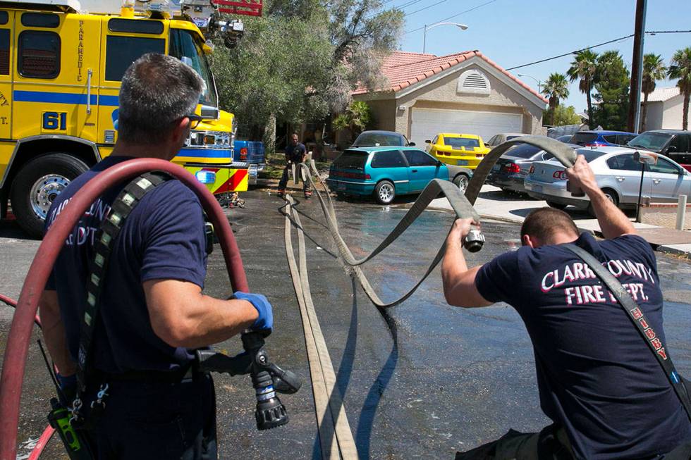 The Clark County firefighters wrap up after battling a shed fire that spread to the home in the ...