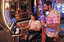Arash Shahbazian and Michelle Muniz of Los Angeles play a slot machine at the Bellagio on the S ...