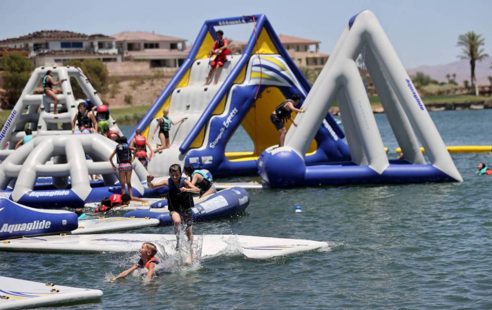 People play at the recently opened Aqua Park at Lake Las Vegas in Henderson Thursday, June 11, ...