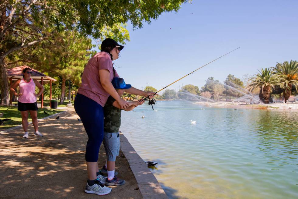 Emily Adinolfi watches as Kate Stone teaches her son Bergen Stone, 6, how to cast his fishing r ...