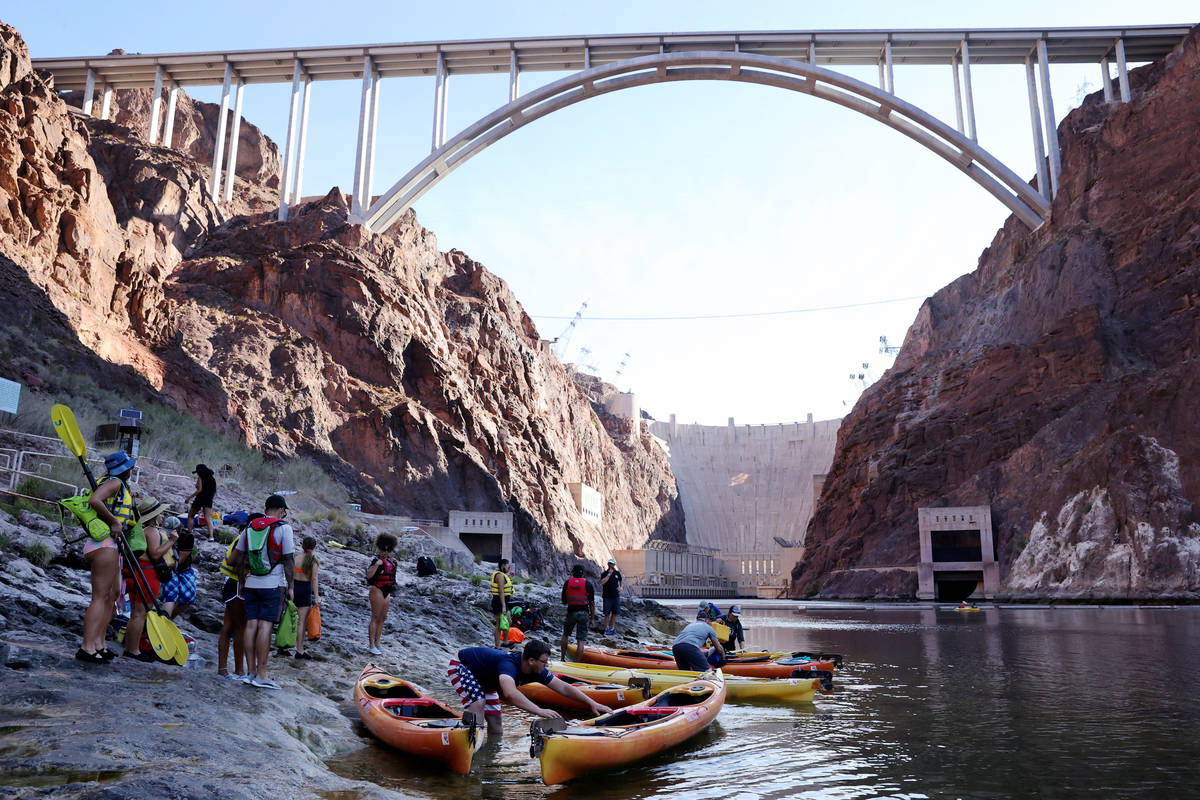 People prepare for a day of kayaking in Black Canyon at the base of the Hoover Dam with Desert ...