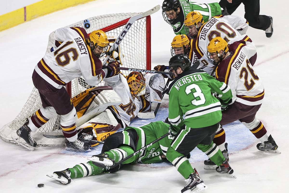 Minnesota Golden Gophers goaltender Mat Robson (40) defends his goal on his back as North Dakot ...