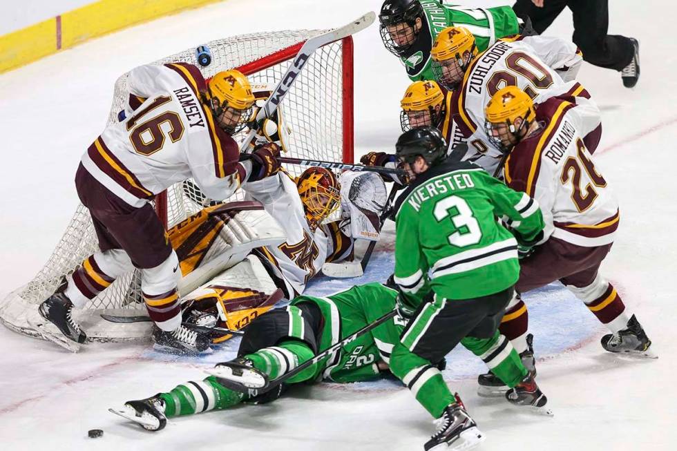 Minnesota Golden Gophers goaltender Mat Robson (40) defends his goal on his back as North Dakot ...