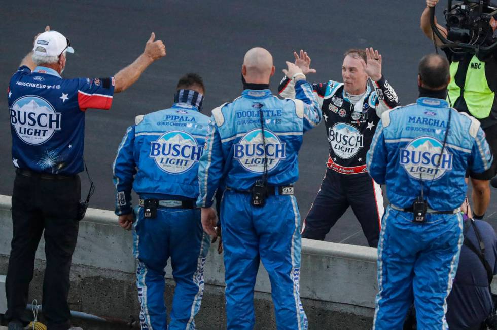 Kevin Harvick, on far side of wall, celebrates with his crew after winning the NASCAR Cup Serie ...