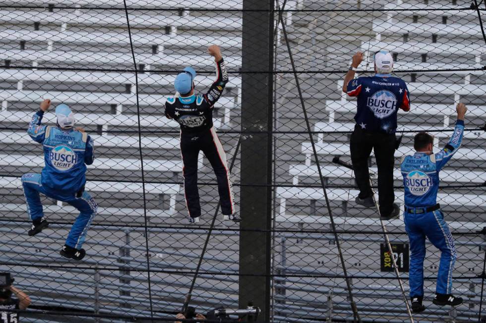 Kevin Harvick, second from left, and some members of the team's crew climb the fence after Harv ...