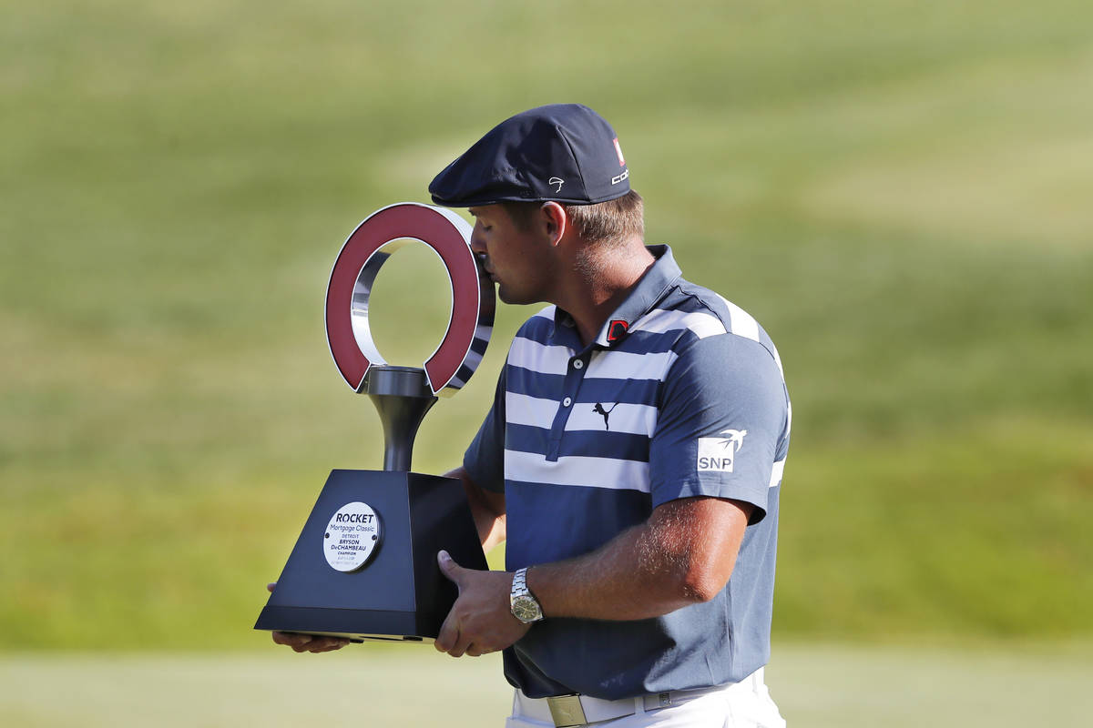 Bryson DeChambeau kisses the Rocket Mortgage Classic golf tournament trophy Sunday, July 5, 202 ...