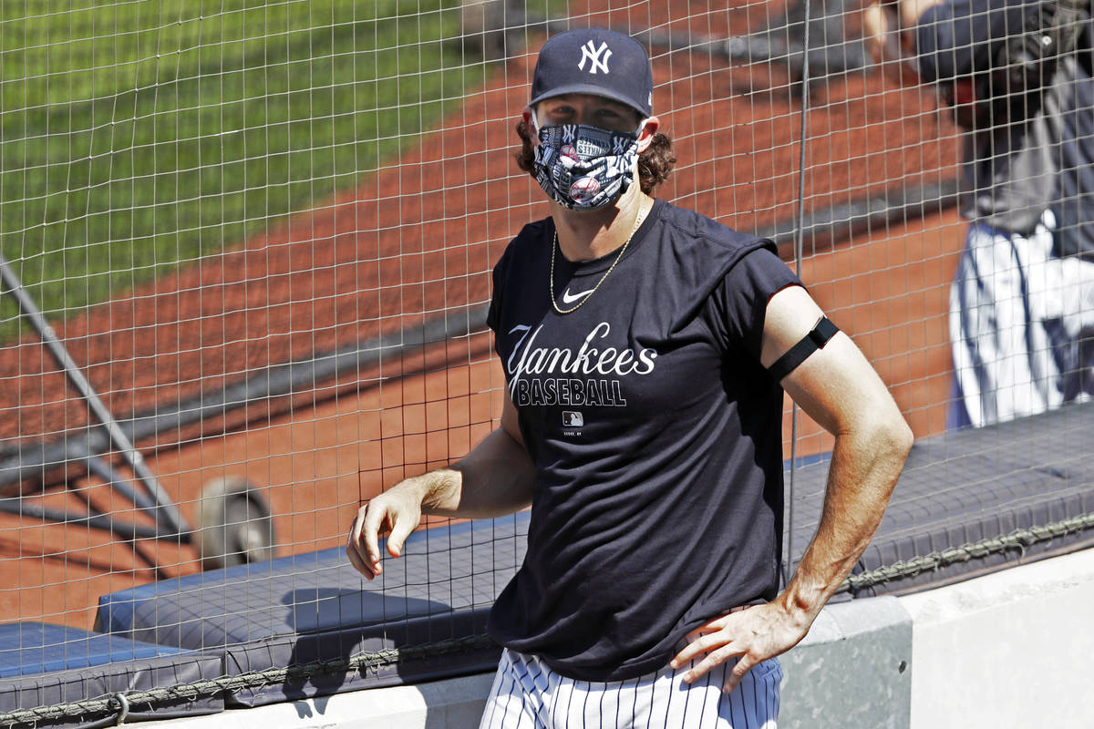 New York Yankees starting pitcher Gerrit Cole looks into the stands, empty except for a handful ...