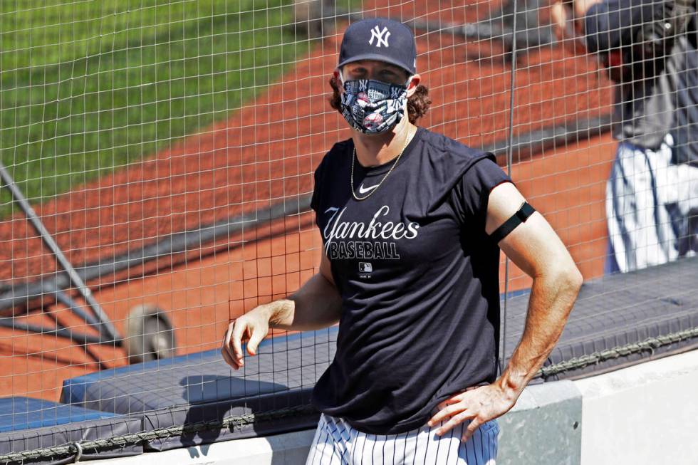 New York Yankees starting pitcher Gerrit Cole looks into the stands, empty except for a handful ...