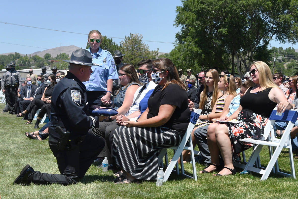 Nevada Highway Patrol Capt. James Simpson presents a folded, American flag to Sgt. Benjamin Jen ...