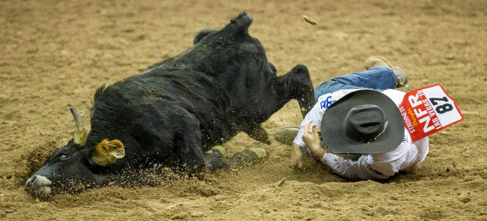 J.D. Struxness of Milan, Minn., mistimes the leap and eats some dirt in Steer Wrestling during ...