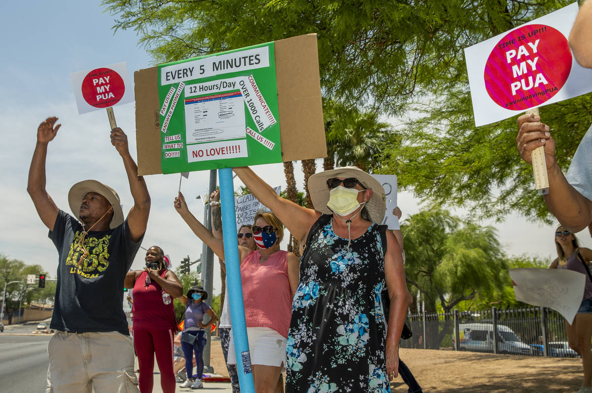 Gig workers gather with signs and wave to passing motorists along E. Washington Ave. to protest ...