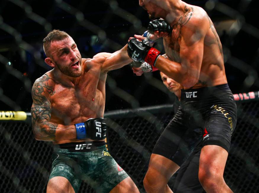 Alexander Volkanovski, left, fights Max Holloway during their featherweight title boutÊin ...