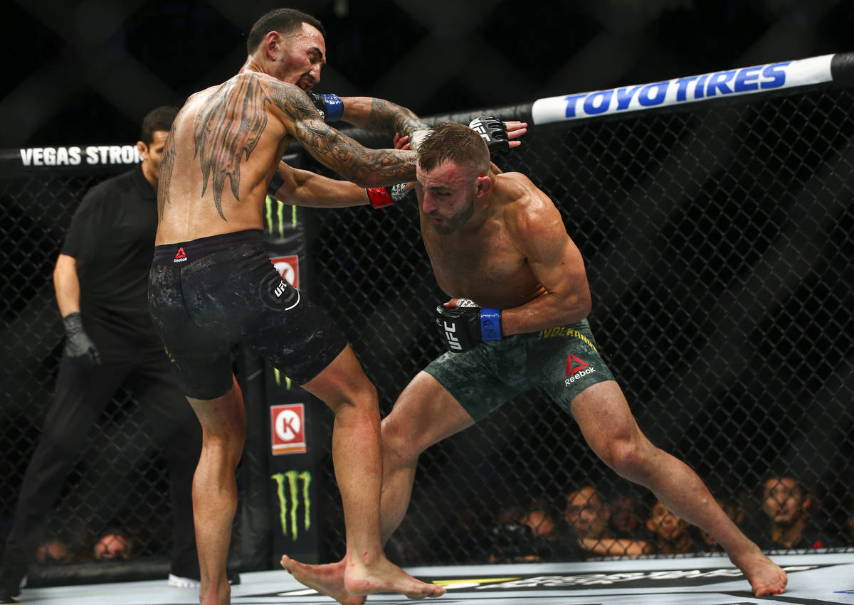 Max Holloway, left, fights Alexander Volkanovski during their featherweight title boutÊin UFC ...