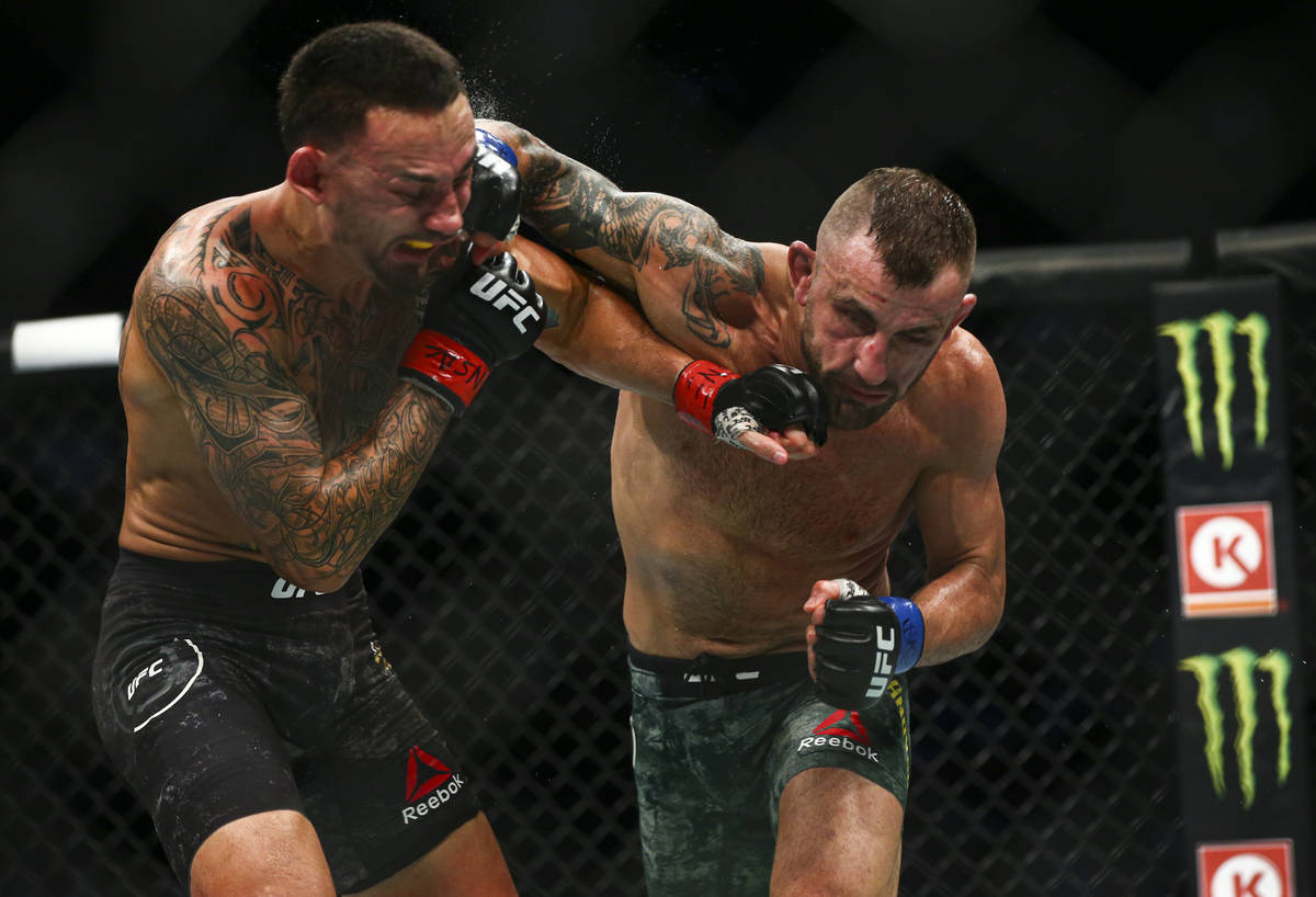 Max Holloway, left, fights Alexander Volkanovski during their featherweight title boutÊin UFC ...