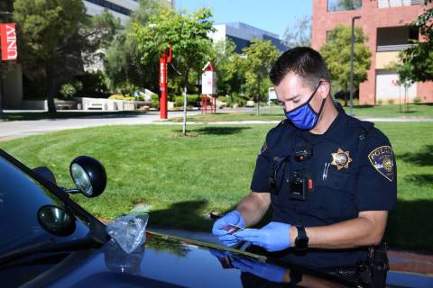 University Police Department officer Ryan Willman checks a bag with credit cards found by campu ...