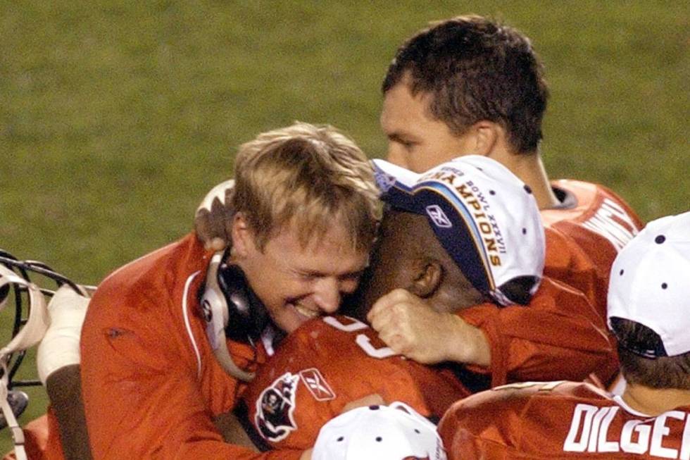 Tampa Bay Buccaneers coach Jon Gruden, left, hugs defensive lineman Warren Sapp as the game aga ...